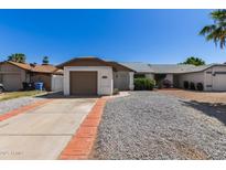 Charming single-story home with a brown garage door and low-maintenance landscaping at 1633 E Beverly Ln, Phoenix, AZ 85022
