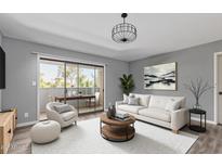 Bright living room featuring a modern sofa, stylish decor, and access to a balcony with outdoor seating at 1730 W Emelita Ave # 2027, Mesa, AZ 85202