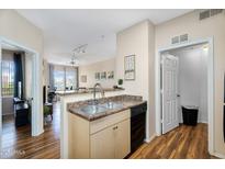 Open-concept kitchen with stainless steel sink and a view into the living room at 18416 N Cave Creek Rd # 3034, Phoenix, AZ 85032