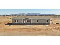 Single-story home featuring a white front door, neutral siding, and mountain views at 23117 W Duane Ln, Wittmann, AZ 85361