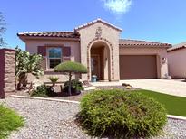 Charming home with desert landscaping, front lawn, stone accents, and an arched entryway to the front door at 3780 E Rakestraw Ln, Gilbert, AZ 85298