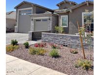 Beautifully landscaped front yard with stone accents and a paved driveway offers great curb appeal at 11074 W Tonto St, Avondale, AZ 85323