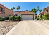 Charming home featuring a red tile roof, two-car garage, and drought-resistant landscaping at 1425 E Commerce Ave, Gilbert, AZ 85234