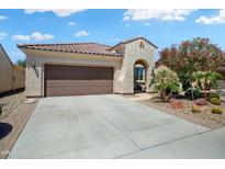 Charming home featuring a tile roof, desert landscaping, and a spacious driveway leading to a two-car garage at 26456 W Cat Balue Dr, Buckeye, AZ 85396