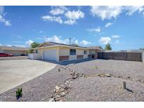 Charming single story home featuring an expansive driveway with low maintenance desert landscaping at 7001 E Flossmoor Ave, Mesa, AZ 85208