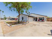 Charming single-story home with a well-manicured lawn, covered front porch, and attached two car garage at 1017 S San Jose Cir, Mesa, AZ 85202