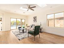 Bright living room with skylight, wood floors, and sliding glass doors to the backyard at 10276 E Meandering Trail Ln, Gold Canyon, AZ 85118
