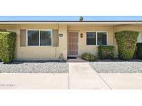 Inviting front entrance with security door, manicured shrubbery and gravel landscaping at 10921 W Santa Fe Dr, Sun City, AZ 85351