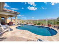 Inviting pool with desert landscaping, privacy fence and covered patio, offering a tranquil outdoor retreat at 12027 S 183Rd Dr, Goodyear, AZ 85338