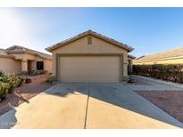 Home exterior features a two car garage and low maintenance landscaping with cactus at 12034 W Aster Dr, El Mirage, AZ 85335