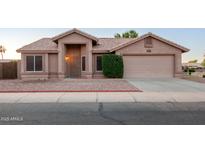 Charming single-story home featuring a neutral stucco exterior, tile roof, and well-maintained landscaping at 1220 S Wagon Wheel Dr, Chandler, AZ 85286