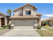 Charming two-story home featuring a tile roof, well-maintained lawn, and a convenient two-car garage at 1310 E Helena Dr, Phoenix, AZ 85022