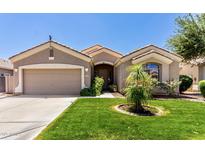 Charming home featuring a well-manicured lawn, desert landscaping and neutral color palette at 13213 W Jacobson Dr, Litchfield Park, AZ 85340
