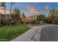 Elegant two-story home featuring lush landscaping, mature trees, and a curved walkway leading to the entrance at 1356 E Flamingo Ct, Gilbert, AZ 85297