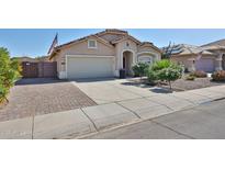 Charming single-story home featuring a two-car garage, desert landscaping, and an American flag at 15731 W Redfield Rd, Surprise, AZ 85379