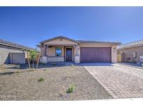 Charming single-story home featuring a desert landscape, neutral color palette, and a two-car garage at 17803 W Elm St, Goodyear, AZ 85395