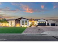 Charming single-story home featuring stone accents, lush lawn, manicured landscaping, and a two-car garage at 20165 E Via Del Palo Dr, Queen Creek, AZ 85142