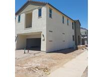 Two-story home under construction with a two-car garage and tan stucco exterior, next to a sidewalk at 2469 W Rowel Rd, Phoenix, AZ 85085