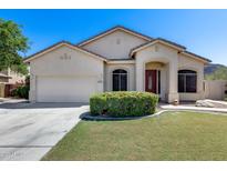 Attractive single-story home featuring a two-car garage and lush green landscaping at 6742 W El Cortez Pl, Peoria, AZ 85383