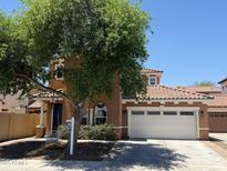 Charming two-story home with a well-manicured lawn, a two-car garage and mature tree providing shade at 9132 S Parkside Dr, Tempe, AZ 85284