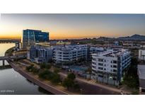 Stunning aerial view of modern apartment complex featuring palm trees and a tranquil river view at sunset at 945 E Playa Del Norte Dr # 1022, Tempe, AZ 85288