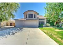 Inviting two-story home with a three-car garage, mature trees, and a well-manicured lawn at 1361 E Sheffield Ave, Gilbert, AZ 85296