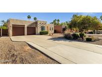 Charming home featuring a stucco facade, desert landscaping, and a spacious driveway leading to a two-car garage at 1554 E Kings Ct, Gilbert, AZ 85234