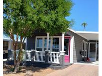 Charming home featuring a covered front porch and a vibrant pink front door at 201 S Greenfield Rd # 215, Mesa, AZ 85206