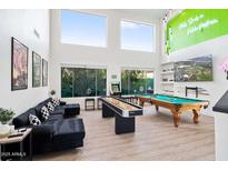 Spacious game room featuring a pool table, shuffleboard table, arcade game, and comfortable seating area at 29228 N 48Th St, Cave Creek, AZ 85331