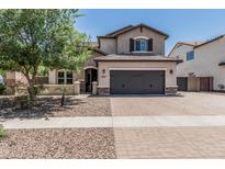 Charming two-story home featuring a spacious driveway, desert landscaping, and a two-car garage at 3067 E Trigger Way, Gilbert, AZ 85297