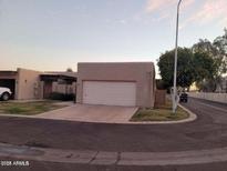 Beige single-story home featuring an attached two-car garage and desert landscaping at 3345 E University Dr # 47, Mesa, AZ 85213