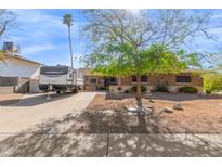 Charming single-story home with a well-maintained front yard and a RV trailer parked in the driveway at 4804 S Elm St, Tempe, AZ 85282