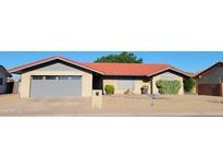 Charming single-story home with a well-maintained front yard and appealing brick facade at 650 N 65Th Way, Mesa, AZ 85205
