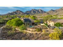 Stunning aerial view of the home with a pool, desert landscaping, and scenic mountain backdrop at 10875 E Mirasol Cir, Scottsdale, AZ 85255