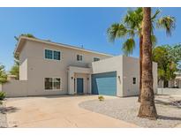Contemporary home showcasing clean lines, a blue garage door, desert landscaping, and palm trees at 1131 E Bishop Dr, Tempe, AZ 85282