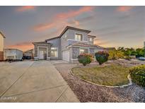 Charming two-story home featuring a well-manicured lawn, stone accents, and a spacious driveway at 13625 W Peck Ct, Litchfield Park, AZ 85340