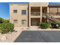 Two-story condo with a beige exterior, front porch, exterior stairs, and desert landscaping at 13805 N Hamilton Dr # H102, Fountain Hills, AZ 85268