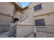 Condominium building with light brown stucco and painted house number 2072 and several windows with screens at 15050 N Thompson Peak Pkwy # 2072, Scottsdale, AZ 85260