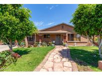 Charming home featuring a stone walkway and well-manicured lawn with mature trees at 2207 N 53Rd Ave, Phoenix, AZ 85035