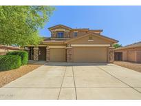 Charming two-story home features a wide driveway, stone accents, and a welcoming facade, perfect for Gathering living at 2592 E San Rafael Trl, Casa Grande, AZ 85194
