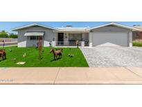 Charming home featuring an immaculate lawn, manicured landscaping, and brick-paved driveway at 5122 E Emerald Cir, Mesa, AZ 85206