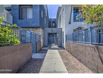 A beautifully landscaped walkway entrance into a modern apartment complex featuring secure gated access at 615 E Portland St # 261, Phoenix, AZ 85004