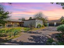 Charming single story home featuring lush landscaping, a detached garage and a stone pathway at 6418 E Sunnyside Dr, Scottsdale, AZ 85254