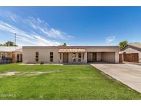 Charming single-story home with a well-manicured lawn and light brickwork against a bright blue sky at 908 S Kachina --, Mesa, AZ 85204