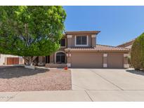 Charming home with a three car garage and a large shade tree in the front yard at 991 N Quail Ln, Gilbert, AZ 85233
