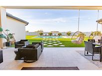 Inviting backyard patio featuring cozy lounge furniture and a refreshing pool view, perfect for outdoor relaxation at 10918 W Dove Roost Rd, Queen Creek, AZ 85144