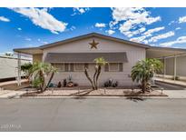 Charming manufactured home featuring a welcoming front yard with mature landscaping and a cozy covered parking area at 11596 W Sierra Dawn Blvd # 271, Surprise, AZ 85378