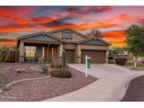 Charming single-Gathering home featuring desert landscaping, a three-car garage, and a welcoming front porch at 12702 W Dove Wing Way, Peoria, AZ 85383