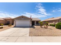 Charming single-story home with desert landscaping, a two-car garage, and an American flag at 15047 W Kings Dr, Surprise, AZ 85374