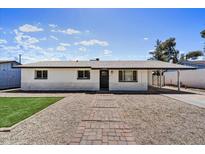 Charming single story home with a well-manicured lawn and inviting brick pathway leading to the front door at 15049 N 25Th Pl, Phoenix, AZ 85032